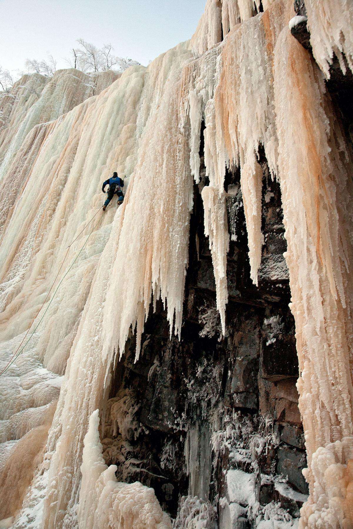 A climber on a frozen waterfall in Finnish Lapland