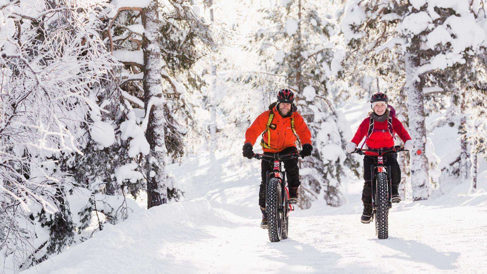 Fat biking a groomed forest trail in winter near Pyhä, Finnish Lapland