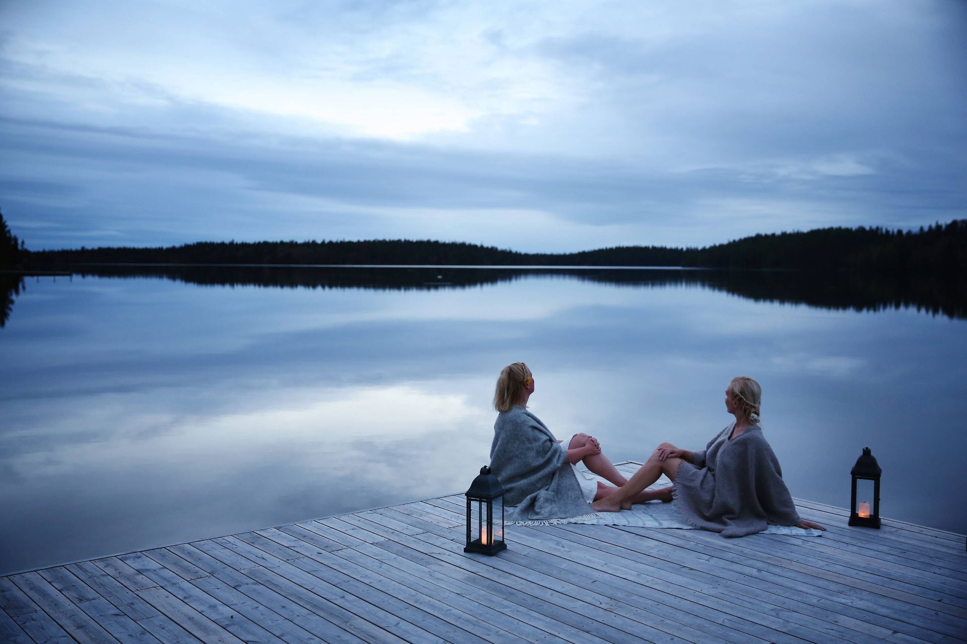 Two women on a lakeside dock after sauna, Finnish Lakeland