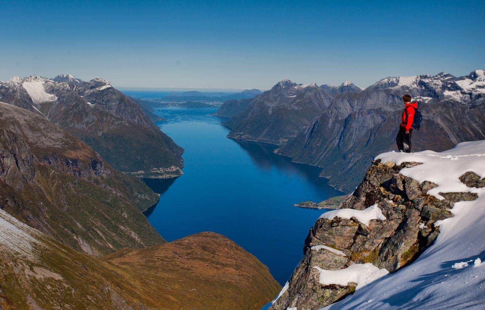 A hiker on Otåla looking down the Hjørundfjord, Sunnmøre